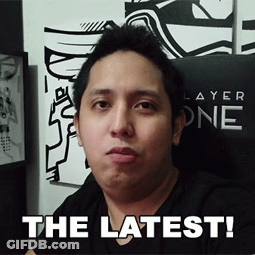 A Man In A Black Shirt Is Sitting In Front Of A Sign That Says " The Latest " GIF