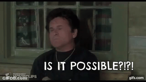 A Man In A Black Shirt Is Sitting In Front Of A Window . GIF