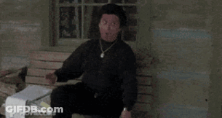 A Man In A Black Shirt Is Sitting On A Wooden Bench GIF