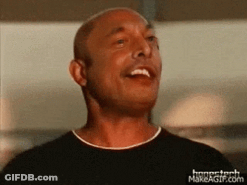 A Man In A Black Shirt Is Smiling And Looking Up At The Sky GIF