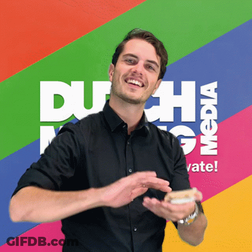 A Man In A Black Shirt Is Smiling In Front Of A Colorful Background That Says Dutch Media GIF
