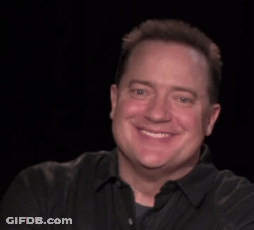A Man In A Black Shirt Is Smiling With The Words Look At Behind Him GIF