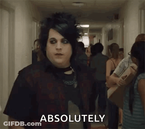 A Man In A Black Shirt Is Standing In A Hallway With A Crowd Of People And Says `` Absolutely '' . GIF