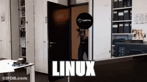 A Man In A Black Shirt Is Standing In A Room With The Word Linux On The Bottom GIF