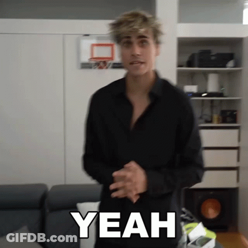 A Man In A Black Shirt Is Standing In Front Of A Basketball Hoop And Says Yeah GIF