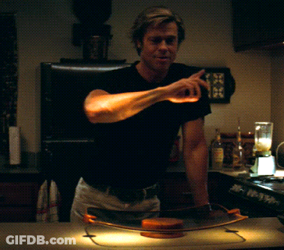 A Man In A Black Shirt Is Standing In Front Of A Blender GIF