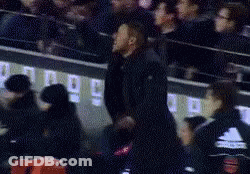 A Man In A Black Shirt Is Standing In Front Of A Crowd In A Stadium In A Blurry Photo . GIF