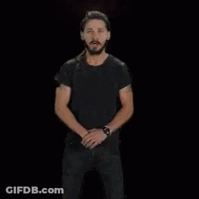 A Man In A Black Shirt Is Standing In Front Of A Fire With The Words Do It In White Letters GIF