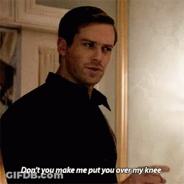 A Man In A Black Shirt Is Standing In Front Of A Mirror And Talking To Someone . GIF