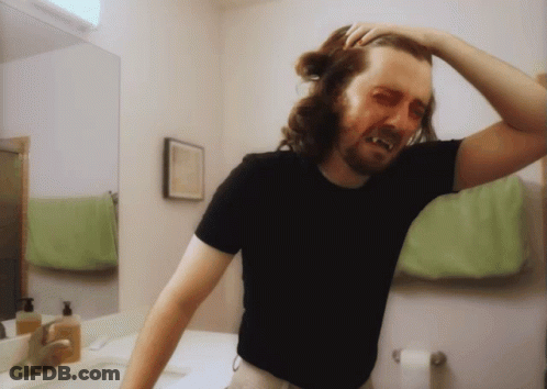 A Man In A Black Shirt Is Standing In Front Of A Mirror GIF