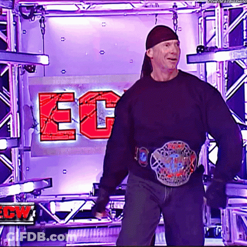 A Man In A Black Shirt Is Standing In Front Of A Sign That Says Ecw GIF