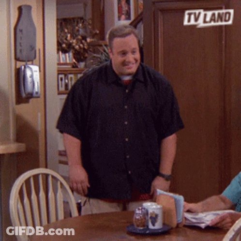 A Man In A Black Shirt Is Standing In Front Of A Tv Land Sign GIF