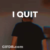 A Man In A Black Shirt Is Standing In Front Of A Wall With The Words `` I Quit '' On It . GIF