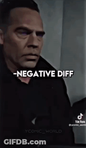 A Man In A Black Shirt Is Standing In Front Of A Wall With The Words `` Negative Diff '' Written On It . GIF