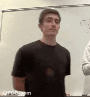 A Man In A Black Shirt Is Standing In Front Of A White Board With The Letter T Drawn On It GIF