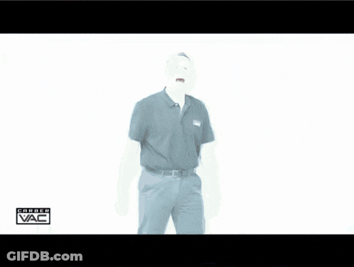 A Man In A Black Shirt Is Standing In Front Of A White Wall With The Word Vac Written On It GIF