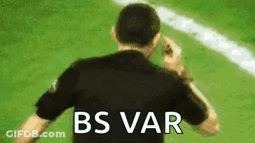 A Man In A Black Shirt Is Standing On A Soccer Field With The Words `` Bs Var '' Written On His Back . GIF