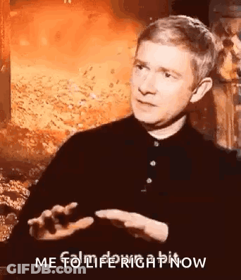 A Man In A Black Shirt Is Talking In Front Of A Fire And Says `` Me To Life Right Now '' . GIF