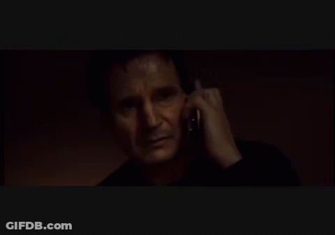A Man In A Black Shirt Is Talking On A Cell Phone GIF