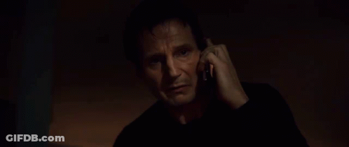A Man In A Black Shirt Is Talking On A Cell Phone . GIF