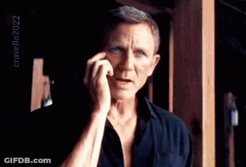 A Man In A Black Shirt Is Talking On A Cell Phone With The Year 2022 In The Corner GIF