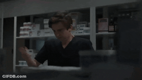 A Man In A Black Shirt Is Talking To A Doctor In A White Coat GIF