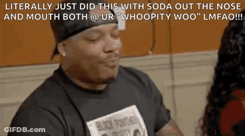 A Man In A Black Shirt Is Talking To A Woman In A Room . GIF