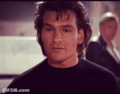 A Man In A Black Shirt Looks At The Camera GIF
