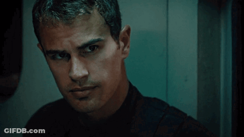 A Man In A Black Shirt Looks At The Camera GIF