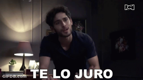 A Man In A Black Shirt Says Te Lo Juro In A Dark Room GIF