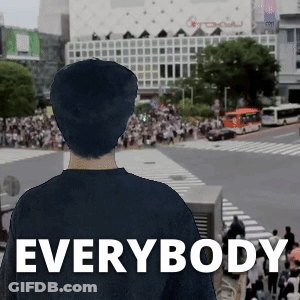 A Man In A Black Shirt Stands In Front Of A Crowd With The Word Everybody On The Bottom Right GIF
