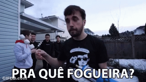 A Man In A Black Shirt Stands In Front Of A Group Of People With The Words Pra Que Fogeira Written Below Him GIF