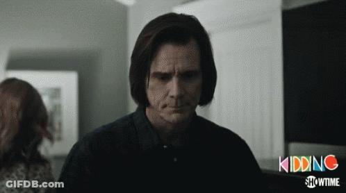 A Man In A Black Shirt Stands In Front Of A Sign That Says Kidding GIF