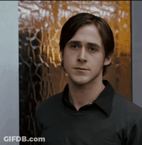 A Man In A Black Shirt Stands In Front Of A Window GIF