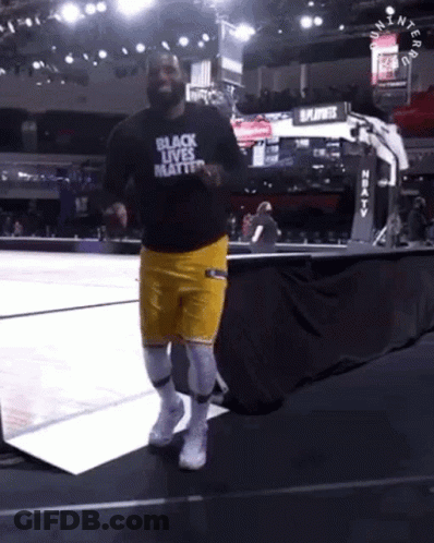 A Man In A Black Shirt That Says Black Lives Matter Is Running On A Basketball Court GIF