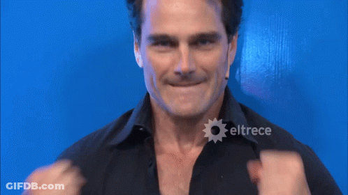 A Man In A Black Shirt With Eltrece On The Bottom Right GIF