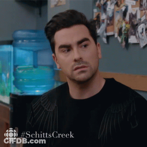 A Man In A Black Shirt With #Schitts Creek On The Bottom GIF
