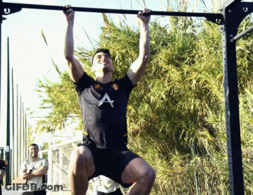 A Man In A Black Shirt With The Letter A On It Is Doing Pull Ups GIF