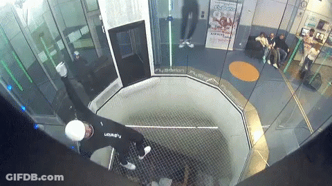 A Man In A Black Shirt With The Letter A On It Is In A Room GIF