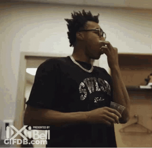 A Man In A Black Shirt With The Word Chicago On It Holds A Cup GIF