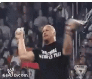 A Man In A Black Shirt With The Word Destroyo On It Is Raising His Fist In The Air In Front Of A Crowd . GIF