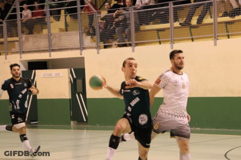 A Man In A Black Shirt With The Word Gaban On It Is Holding A Ball GIF