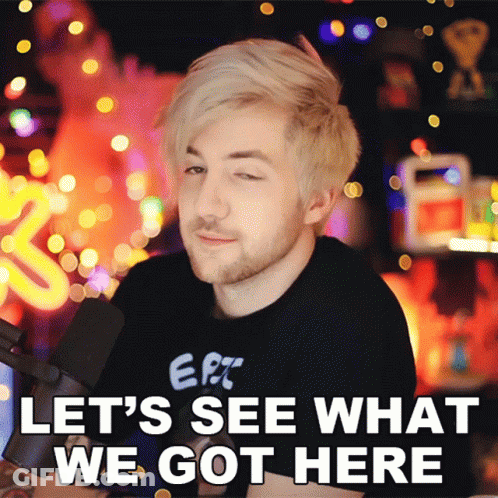 A Man In A Black Shirt With The Words Let 'S See What We Got Here On The Bottom GIF