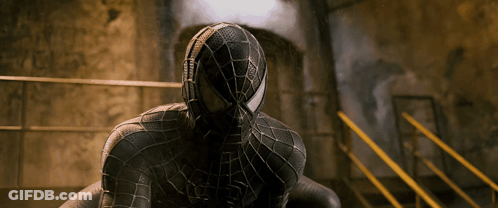 A Man In A Black Spiderman Costume Is Sitting On A Staircase GIF