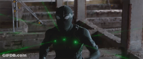 A Man In A Black Spiderman Costume Is Surrounded By Green Lasers GIF