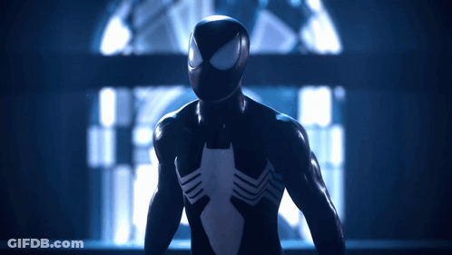 A Man In A Black Spiderman Suit Stands In A Dark Room GIF