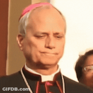 A Man In A Black Suit And A Pink Hat Looks Down GIF