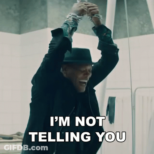 A Man In A Black Suit And Hat Says I 'M Not Telling You While Holding Up His Hands GIF