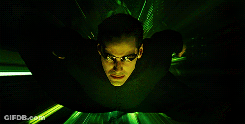 A Man In A Black Suit And Sunglasses Is Flying Through A Green Light GIF