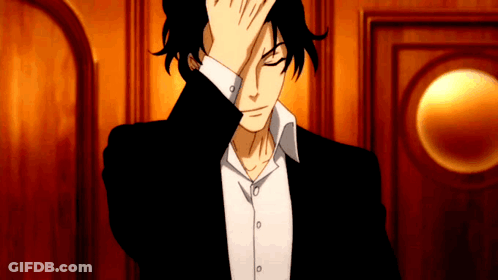 A Man In A Black Suit And White Shirt Is Covering His Face With His Hand GIF